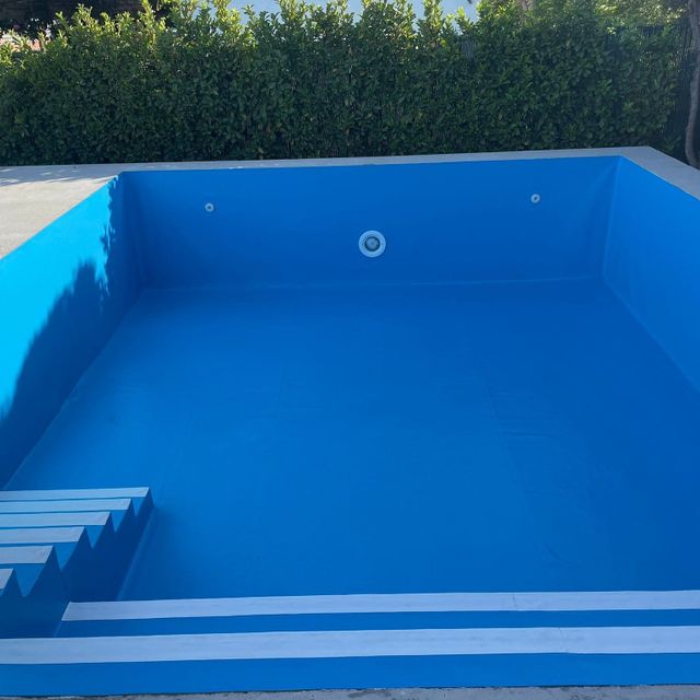 piscina azul con escaleras y banco